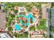 Stunning aerial view of resort-style pool area with lazy river, slides, palm trees and many lounge chairs at 3938 Calabria Ave, Davenport, FL 33897