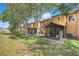 View of a lawn with a screened in patio and trees in the backyard at 3938 Calabria Ave, Davenport, FL 33897