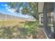 A grassy backyard with an enclosed patio and a long fence beyond at 3938 Calabria Ave, Davenport, FL 33897