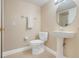 Cozy bathroom with pedestal sink, round mirror and a toilet with white seat cover at 3938 Calabria Ave, Davenport, FL 33897