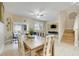 Open-concept dining area with wood table, tile floors, staircase, and access to the living area with mounted TV at 3938 Calabria Ave, Davenport, FL 33897