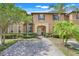 Charming two-story townhome featuring a brick driveway, lush landscaping and a welcoming arched entryway at 3938 Calabria Ave, Davenport, FL 33897