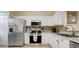 Well-lit kitchen features stainless steel appliances, granite counters, and stylish backsplash at 3938 Calabria Ave, Davenport, FL 33897