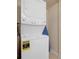 Efficient laundry room with stacked washer and dryer and a displayed energy guide at 3938 Calabria Ave, Davenport, FL 33897