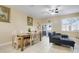 Open-concept living and dining area with tile flooring, comfortable sofa, dining table with seating, and sliding glass doors at 3938 Calabria Ave, Davenport, FL 33897