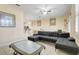 Inviting living room with tile floors, ceiling fan, and comfortable dark gray sofa with a view to the kitchen at 3938 Calabria Ave, Davenport, FL 33897