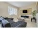 Stylish living room with white plantation shutters, decorative gold accent wall with mounted TV, and comfy sectional sofa at 3938 Calabria Ave, Davenport, FL 33897