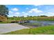 Waterfront property featuring a wooden dock and ramp for easy boat access with lush greenery at 3946 Bigarade Ln, Lake Alfred, FL 33850