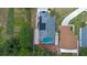 Backyard aerial view featuring a private screened-in pool, lush landscaping, and mature trees at 404 Obo Dr, Davenport, FL 33896