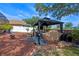 Outdoor kitchen featuring a grill, dining area, and lush landscaping, shaded by mature trees in the backyard at 404 Obo Dr, Davenport, FL 33896