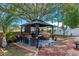 Backyard features a gazebo with an outdoor kitchen including grill and dining area, perfect for entertaining at 404 Obo Dr, Davenport, FL 33896