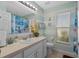 Bright bathroom featuring nautical decor, large mirror, and window for natural light at 404 Obo Dr, Davenport, FL 33896