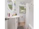 Bright bathroom featuring a vanity with a round mirror, shower with curtain, and a window at 4111 Dublin St, Orlando, FL 32812