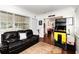 Inviting living room with a comfortable black leather sofa, dark hardwood flooring, and a vintage Pac-Personal arcade game at 4111 Dublin St, Orlando, FL 32812
