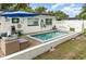 Backyard pool with a blue umbrella, white fence, patio furniture, and well-maintained landscaping at 4111 Dublin St, Orlando, FL 32812
