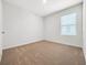 A bright, carpeted bedroom features a window and a neutral color scheme at 437 Caribbean Ct, Kissimmee, FL 34759