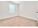 A bright, carpeted bedroom features a window and neutral color scheme at 437 Caribbean Ct, Kissimmee, FL 34759