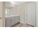 Bathroom with double sink vanity, wood-look flooring, and a large mirror with modern lighting at 4444 Quartz Ct, Lakeland, FL 33811