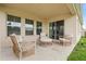 A covered patio features stylish furniture, including wicker chairs and a round table, perfect for relaxing outdoors at 4444 Quartz Ct, Lakeland, FL 33811