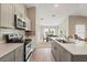 Well-lit kitchen features an island with quartz countertops, stainless appliances, and dining area at 4444 Quartz Ct, Lakeland, FL 33811