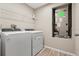 Efficient laundry room with washer, dryer, overhead storage, and wood-look flooring at 4444 Quartz Ct, Lakeland, FL 33811