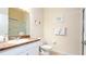 Well-lit bathroom with a vanity, sink, toilet, tile floors, framed art, and a glass-enclosed shower at 515 Rum Run # 33515, Davenport, FL 33897