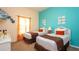 Bedroom featuring two twin beds, vibrant turquoise wall, playful decor, and Mickey Mouse figure at 515 Rum Run # 33515, Davenport, FL 33897