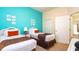 Bedroom with twin beds, turquoise walls, closet, and access to the adjoining room with a small balcony at 515 Rum Run # 33515, Davenport, FL 33897