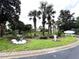 The entrance to Tradewinds with palm trees, decorative landscaping, and signage at 515 Rum Run # 33515, Davenport, FL 33897