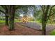 Community playground with a slide and swings, surrounded by mature trees and greenery at 515 Rum Run # 33515, Davenport, FL 33897