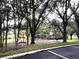 Community playground featuring swings, slides, and climbing structures, all nestled in a lush, green, wooded area at 515 Rum Run # 33515, Davenport, FL 33897