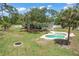 Aerial view of the backyard, featuring a kidney-shaped pool, fire pit, and lush greenery at 530 Lake Bingham Rd, Lake Mary, FL 32746