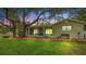Tranquil backyard features a covered patio, mature trees, and ample space for outdoor activities at 530 Lake Bingham Rd, Lake Mary, FL 32746