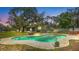 View of the backyard with a kidney-shaped pool, outdoor seating, and lush landscaping at 530 Lake Bingham Rd, Lake Mary, FL 32746