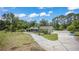Sprawling property features a well-maintained green home, mature trees, and a long gravel driveway at 530 Lake Bingham Rd, Lake Mary, FL 32746
