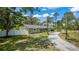 Sprawling property features a well-maintained green home, mature trees, and a long gravel driveway at 530 Lake Bingham Rd, Lake Mary, FL 32746