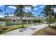 Charming single-story home with fresh green paint, gravel driveway, and tropical landscaping at 530 Lake Bingham Rd, Lake Mary, FL 32746