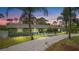 Charming single-story home with fresh green paint, gravel driveway, and tropical landscaping at 530 Lake Bingham Rd, Lake Mary, FL 32746