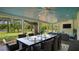 Covered patio with dining table, ceiling fans, and outdoor seating overlooking the lake at 530 Lake Bingham Rd, Lake Mary, FL 32746