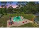 Beautiful kidney-shaped pool with outdoor seating overlooking a picturesque lake and lush greenery at 530 Lake Bingham Rd, Lake Mary, FL 32746