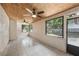 Bright sunroom featuring tile flooring, two ceiling fans, and many windows overlooking the lush backyard at 5436 Tangerine Ave, Winter Park, FL 32792