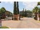 View of the community entrance with a security gate, decorative landscaping, and multiple buildings at 6021 Westgate Dr # 813, Orlando, FL 32835