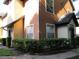 Exterior view of the property, featuring a well-maintained lawn, bushes, and a paved walkway at 6021 Westgate Dr # 813, Orlando, FL 32835