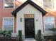 Inviting condo entrance featuring a black front door with a covered porch and well-maintained landscaping at 6021 Westgate Dr # 813, Orlando, FL 32835