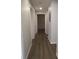Well-lit hallway with wood-look floors, access to multiple rooms, and neutral wall paint at 6021 Westgate Dr # 813, Orlando, FL 32835