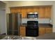 Kitchen featuring wood cabinetry, stainless steel appliances, and dark countertops at 6021 Westgate Dr # 813, Orlando, FL 32835