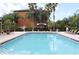 Large community pool with lounge chairs and umbrellas surrounding the pool deck, and palm trees at 6021 Westgate Dr # 813, Orlando, FL 32835