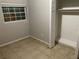 Clean and simple bedroom with a built-in closet, tile floors, and natural light at 6113 Hialeah St, Orlando, FL 32808