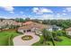 Aerial view of a luxurious home showcasing a circular driveway, fountain, lush landscaping, and a screened pool area at 6233 Rydal Ct, Windermere, FL 34786