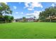 Large backyard features lush green grass and mature trees, showcasing ample space for outdoor activities at 6233 Rydal Ct, Windermere, FL 34786